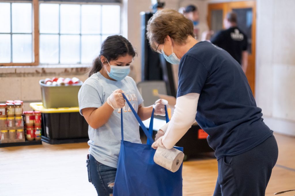 student and teacher packing bag at shelter