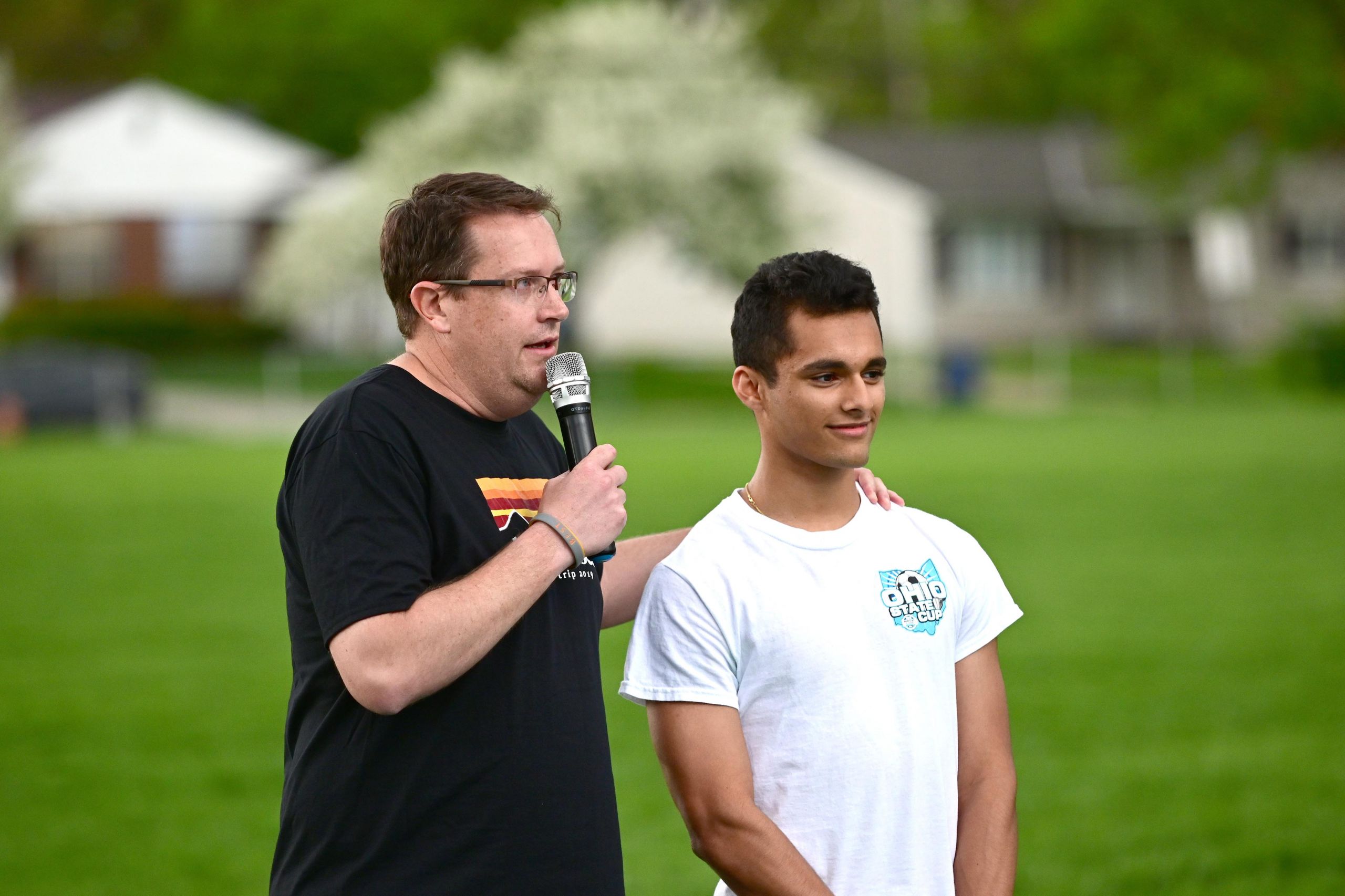 teacher talking to crowd with a student